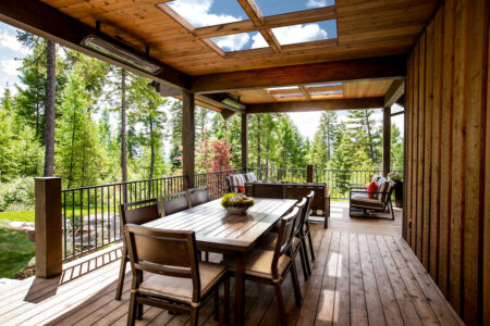 A rustic wooden deck with glass decking inserts in an alpine setting.